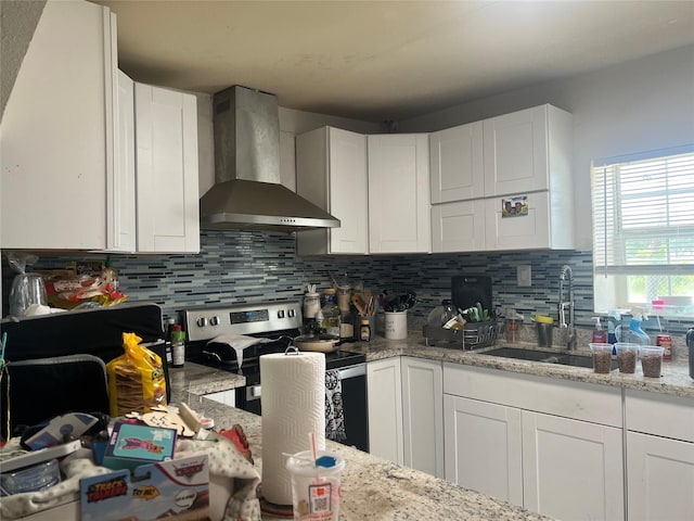 kitchen with white cabinetry, sink, wall chimney range hood, light stone counters, and stainless steel electric range