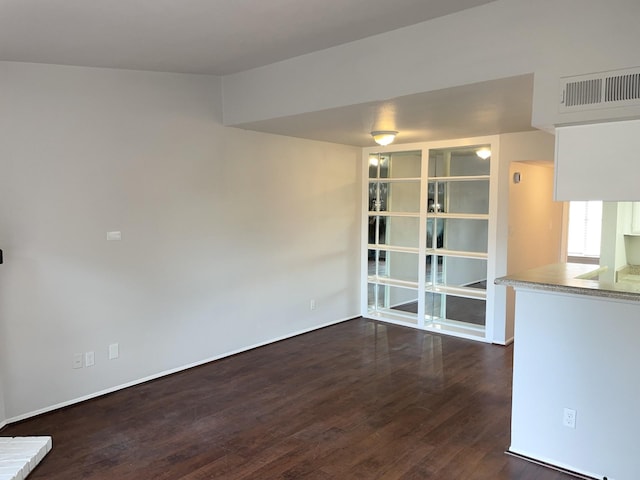 unfurnished dining area featuring dark wood-type flooring