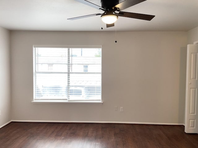 spare room with ceiling fan, a healthy amount of sunlight, and dark wood-type flooring