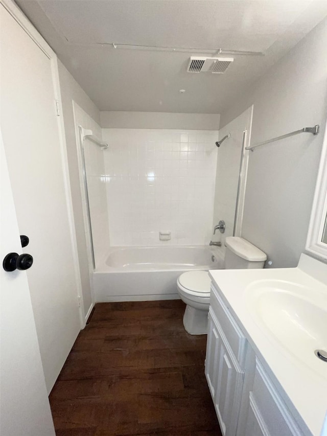 full bathroom with vanity, toilet, tiled shower / bath, and hardwood / wood-style flooring