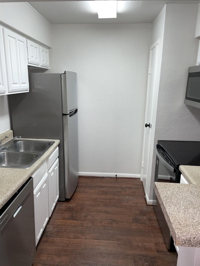 kitchen with dark hardwood / wood-style flooring, white cabinetry, sink, and stainless steel appliances