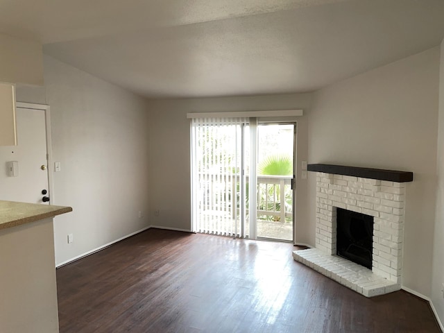 unfurnished living room with a fireplace and dark wood-type flooring