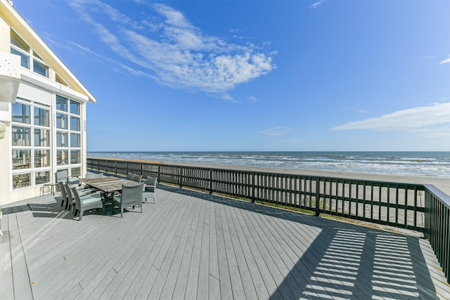 wooden terrace featuring a water view and a view of the beach