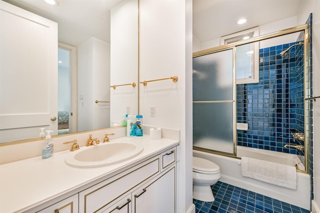 full bathroom featuring toilet, vanity, tile patterned floors, and bath / shower combo with glass door