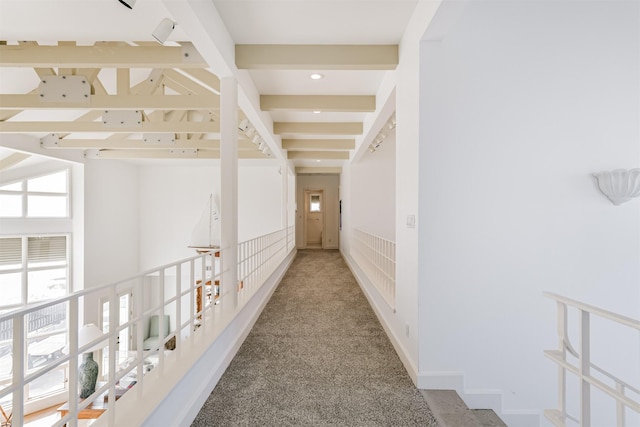 hallway featuring beam ceiling and carpet floors