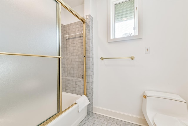 bathroom with tile patterned flooring, toilet, and bath / shower combo with glass door