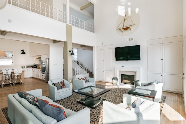 living room featuring a high ceiling and wood-type flooring