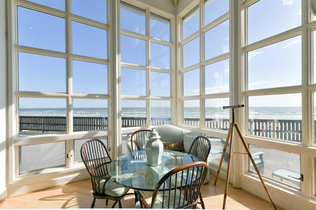 sunroom / solarium with a beach view and a water view