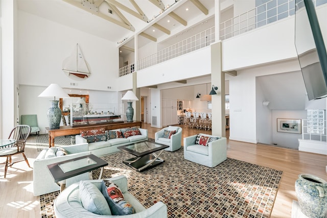 living room featuring a towering ceiling and hardwood / wood-style flooring