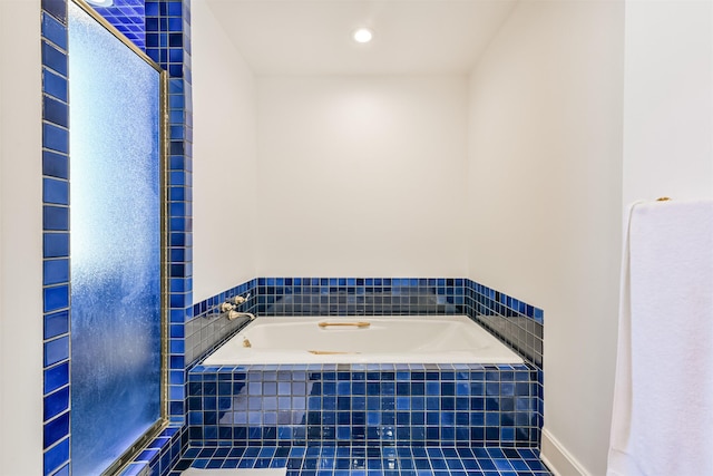 bathroom featuring tile patterned floors and tiled bath