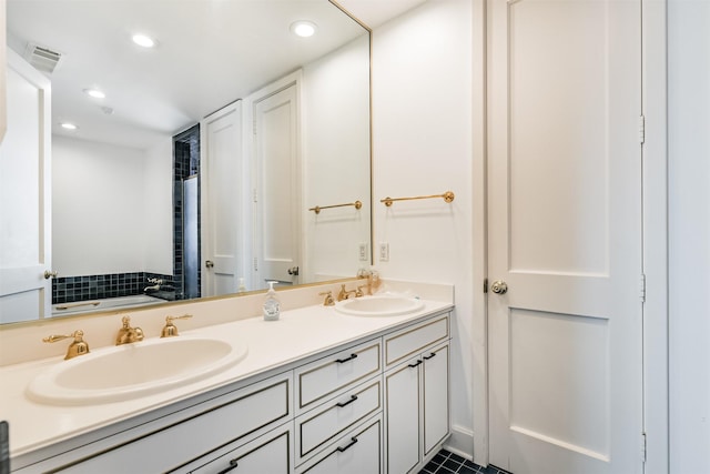 bathroom featuring a washtub, vanity, and tile patterned flooring