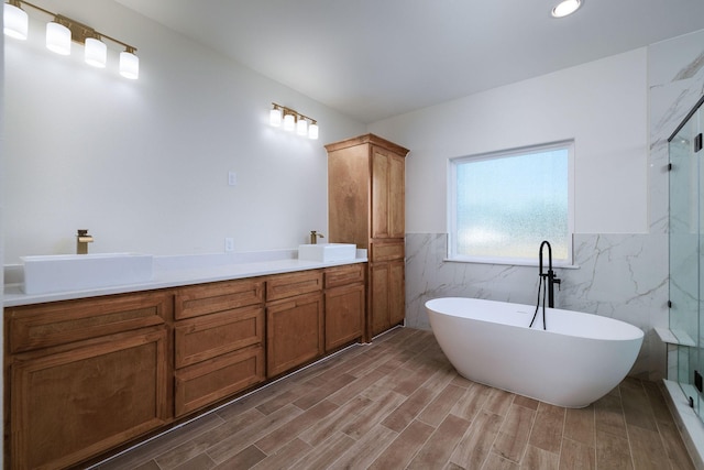 bathroom with wood-type flooring, vanity, a bathtub, and tile walls