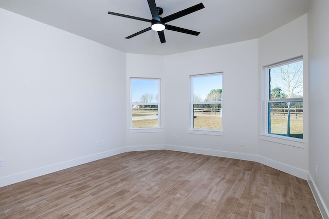 empty room featuring light hardwood / wood-style flooring, ceiling fan, and a healthy amount of sunlight