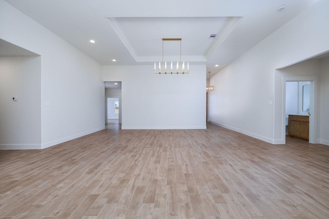 interior space featuring light hardwood / wood-style floors, ornamental molding, and a tray ceiling