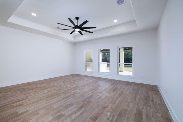 unfurnished room featuring light hardwood / wood-style floors, a raised ceiling, and ceiling fan