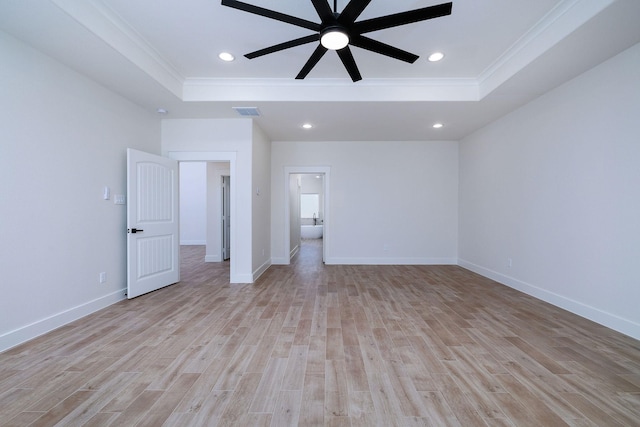 unfurnished bedroom with a raised ceiling, ensuite bath, ceiling fan, and crown molding