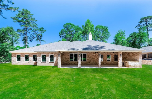 228 Feldspar Ln, Huntsville, TX 77340 - rear view of property with a lawn, a patio, a chimney, and brick siding