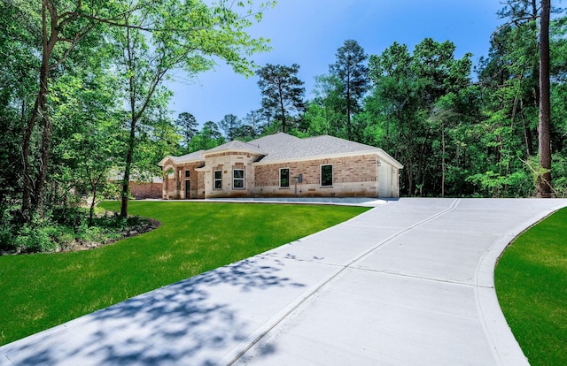 228 Feldspar Ln, Huntsville, TX 77340 - view of front of house with brick siding, a front yard, and driveway