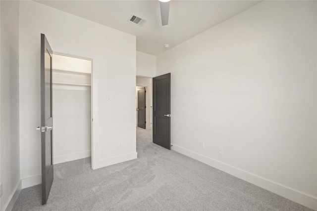 unfurnished bedroom featuring ceiling fan, a closet, and light colored carpet