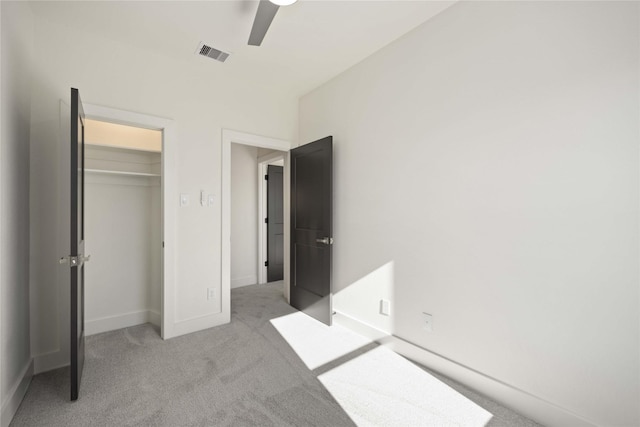 unfurnished bedroom with ceiling fan, a closet, and light colored carpet