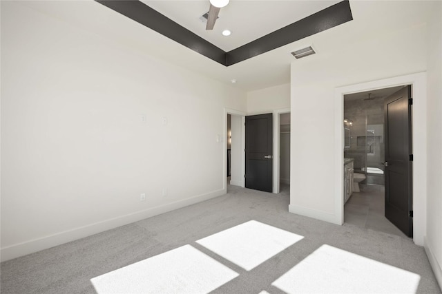 unfurnished bedroom featuring light carpet, ensuite bathroom, and ceiling fan