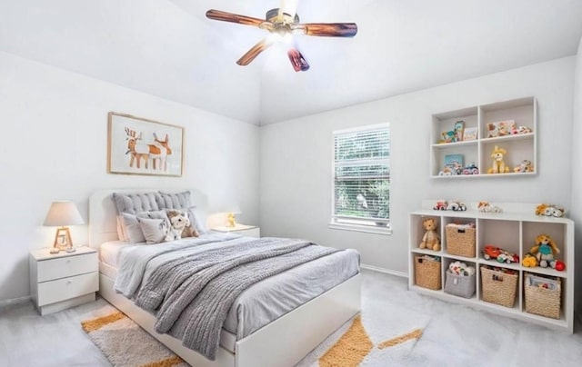 bedroom featuring ceiling fan, light colored carpet, and vaulted ceiling