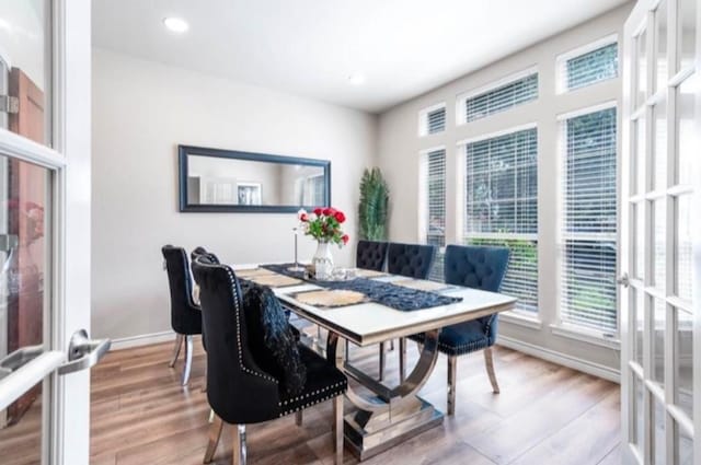 dining area with light hardwood / wood-style floors and french doors