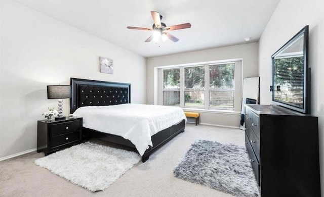 bedroom with ceiling fan and light carpet