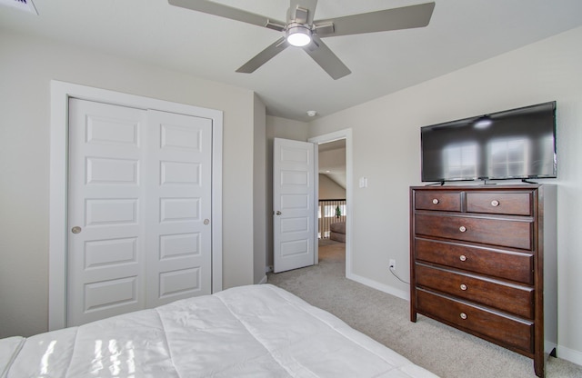 bedroom featuring ceiling fan, light colored carpet, and a closet