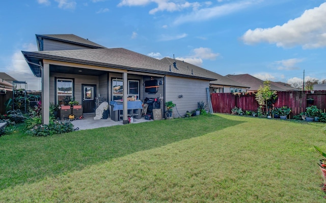 rear view of house with a lawn and a patio