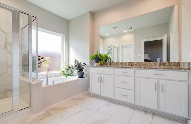 bathroom featuring vanity and independent shower and bath