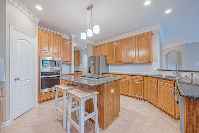 kitchen featuring a center island, sink, stainless steel appliances, backsplash, and pendant lighting