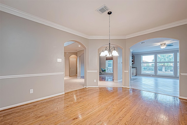 unfurnished room with crown molding, ceiling fan with notable chandelier, and light wood-type flooring