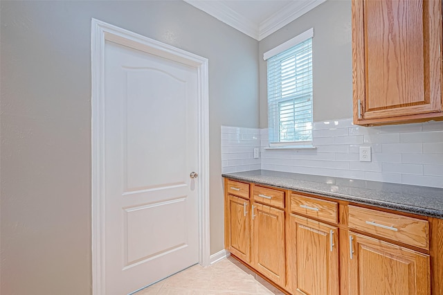 kitchen featuring decorative backsplash, crown molding, and light tile patterned flooring