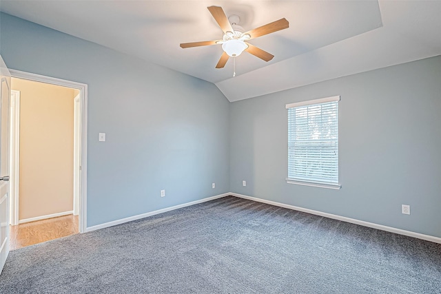 carpeted empty room with ceiling fan and lofted ceiling