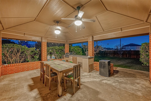 patio terrace at dusk with ceiling fan, area for grilling, and grilling area