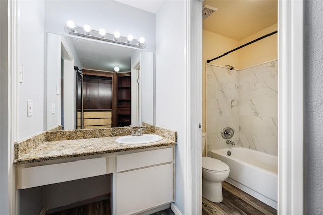 full bathroom with hardwood / wood-style floors, vanity, toilet, and tiled shower / bath