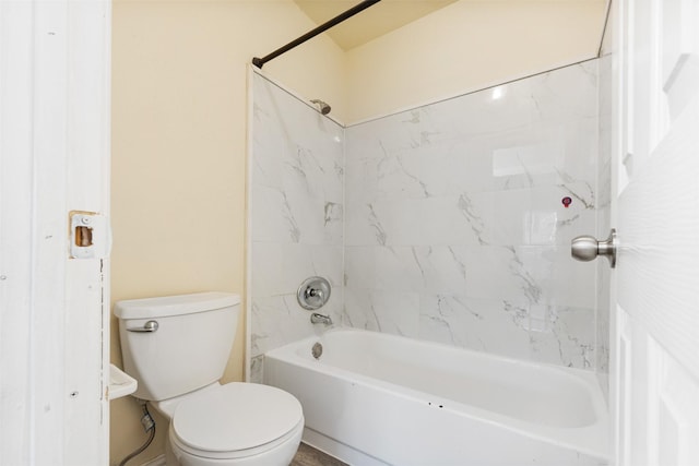 bathroom featuring toilet and tiled shower / bath