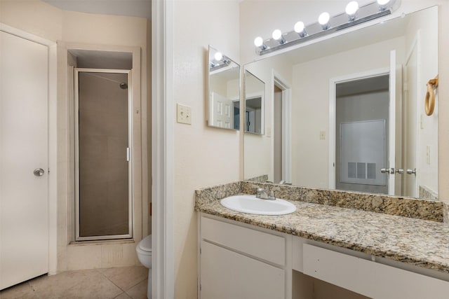 bathroom featuring tile patterned floors, vanity, toilet, and an enclosed shower