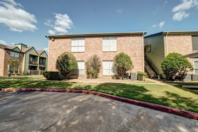 view of front of home with a front yard and cooling unit