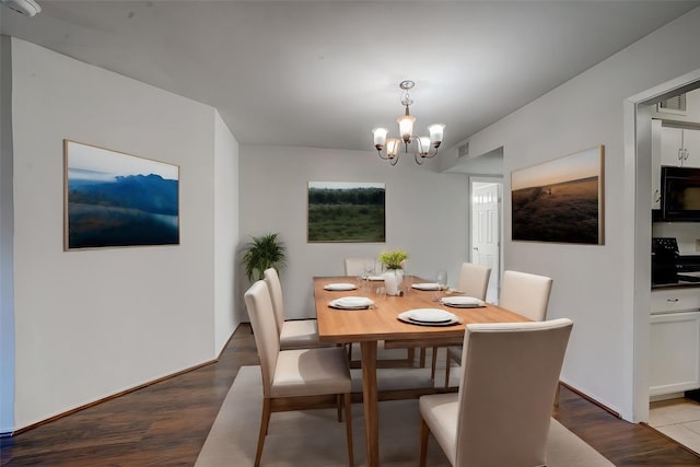 dining room with hardwood / wood-style floors and a chandelier