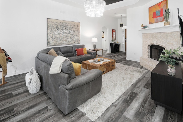 living room with a fireplace, dark hardwood / wood-style floors, and a notable chandelier