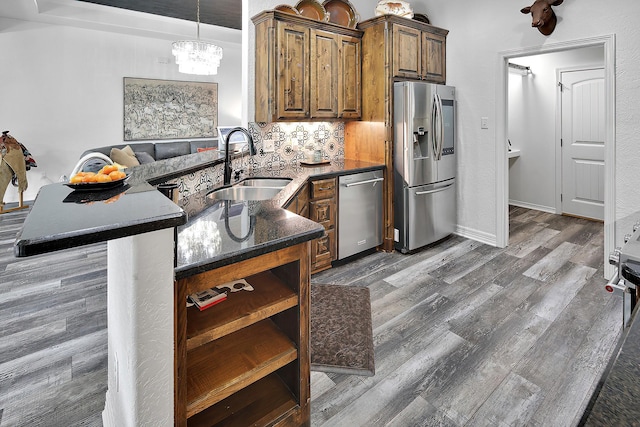 kitchen featuring sink, dark wood-type flooring, stainless steel appliances, backsplash, and a chandelier