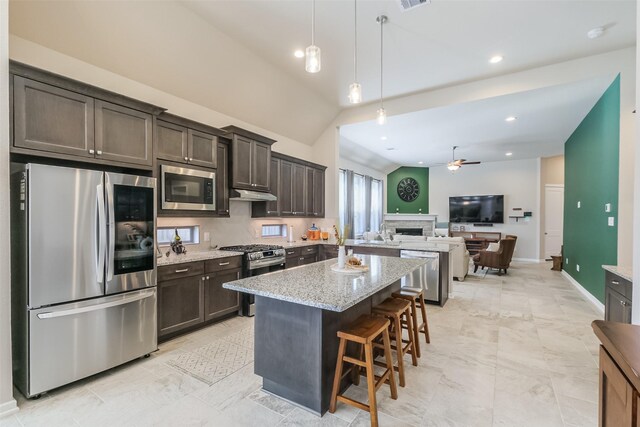 29614 Sterling Knoll Dr, Fulshear, TX 77441 - kitchen with ceiling fan, dark brown cabinets, light stone counters, open floor plan, and stainless steel appliances