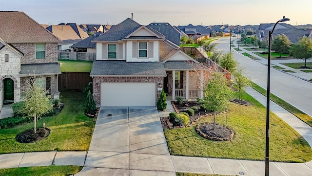 view of front of house with driveway, a front lawn, an attached garage, and a residential view