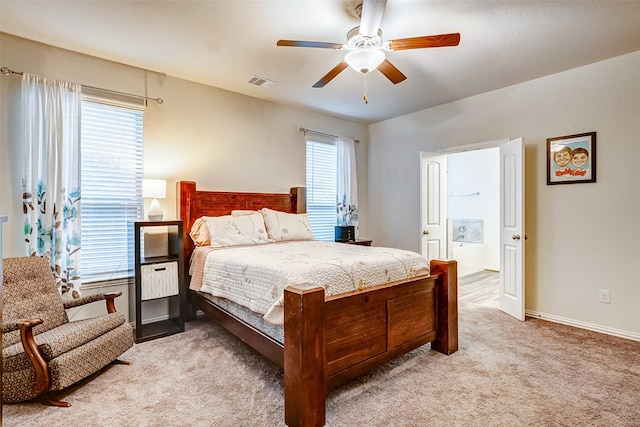 bedroom featuring ceiling fan, light colored carpet, and multiple windows