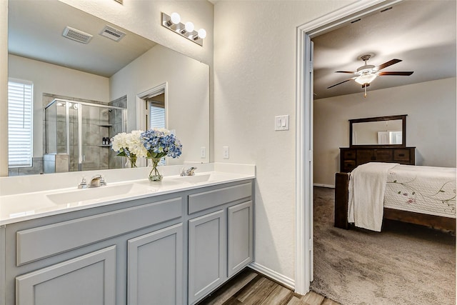 full bathroom featuring a sink, a shower stall, visible vents, and connected bathroom