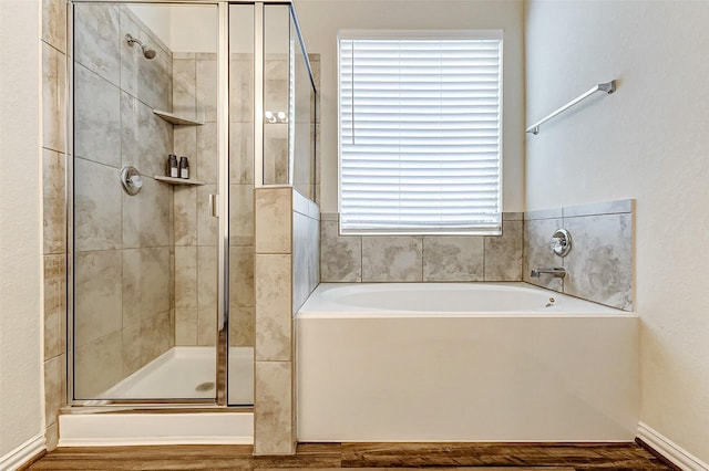 bathroom featuring a shower stall and a bath