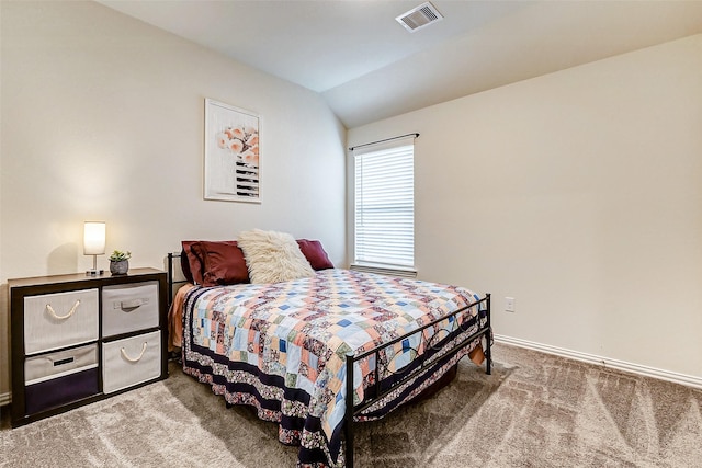 carpeted bedroom with visible vents, vaulted ceiling, and baseboards