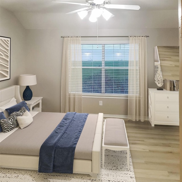 bedroom with ceiling fan, light wood-type flooring, and vaulted ceiling